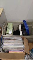 Wide shot of the large plastic bin and cardboard box filled with assorted scrapbooking items including binders and storage boxes