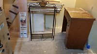 Photo showing metal towel rack, oak stair treads behind it, Singer sewing machine cabinet to right