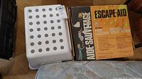 Photo showing one white plastic step stool and the boxed Escape-Aid fire ladder.