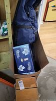 Wooden box containing bocce balls, box of washers, and blue equipment bag