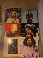 Photo showing six LP album covers laid out: Frampton Comes Alive, Paul Anka, George Benson, Urban Chipmunk, Angie, and one other.
