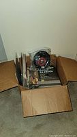 Box showing large quantity of LP vinyl records and one 7 inch vinyl in plastic wrapping.
