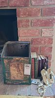 Lot showing vintage books, vintage metal box, child's ballerina slippers, and university pins
