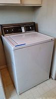 Full front view of Kenmore washing machine with closed lid showing white body and control panel on back.