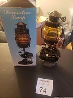 Full view of candle light holder and its box showing amber glass lantern and ship base.