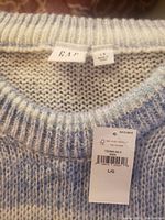 Close-up image of the Gap brand label and size label (Large) with tags attached.