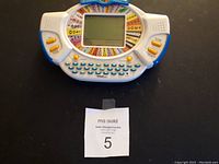 Front view of the Wheel of Future electronic handheld game showing its buttons, circular display, and keyboard.