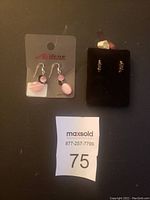 Front view of both pairs of earrings displayed with maxsold tag