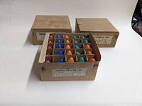 Photo shows the open box of 75 assorted colored C-9 1 1/4 inch Christmas holiday light bulbs in original packaging.