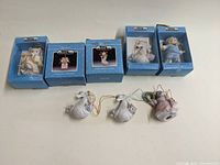 Five vintage Schmid cat porcelain Christmas ornaments in original blue boxes and three out of boxes shown in front.