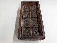 Top-down image of the rectangular wooden mold with eight carved sections.