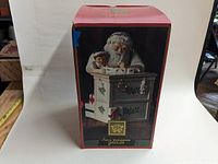 Original red box showing Santa working at desk with child figure and holiday decor on front