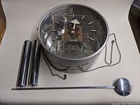 All components laid out on surface: clock body, two weights, pendulum rod and bob