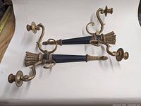 Pair of oriental black and brass Gothic candle wall sconces shown flat on white background