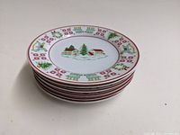 Stack of six Georges Briard Christmas Sampler dessert plates showing the thickness and edge design.