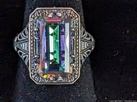 Front view of the sterling silver ring showing large rectangular iridescent stone surrounded by marcasite and detailed filigree metalwork.