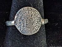 Front view of ring showing detailed Phaistos disk design