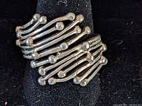 Close-up of sterling silver modernist design ring front showing overlapping curved bars with rounded ends arranged asymmetrically.