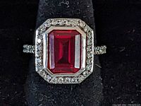 Top view showing the large square red stone surrounded by clear stones on sterling silver ring.