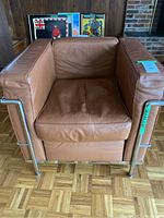 Front view of caramel leather armchair with chrome tubular frame