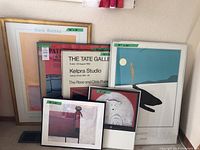 Overview of all framed posters arranged on floor against wall