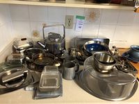 Overall view of assorted metal kitchen items including kettle, trays, dishes, bowls, shakers and mugs