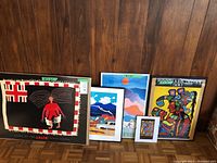 Overview of all four framed artworks against wood-paneled wall