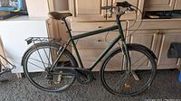 Full side view of a large men's dark green Beater brand 3 speed bike showing frame, saddle, rear rack, chainguard, fenders, and tires.