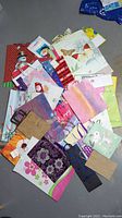 Photo of assorted gift bags spread on the floor showcasing different sizes, colors, and designs.