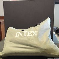 Side view of the Intex inflatable mattress showing the fabric surface and the logo printed on it.