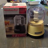 KitchenAid 3.5 cup food chopper with box and lid on a wooden table