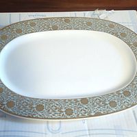 Close-up of the large oval serving platter showing the floral border pattern in blue and brown on white porcelain.