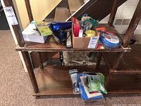 Various hardware items, hairdryer, colored markers, packing tape and assorted small tools on wooden shelving
