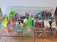 Photo showing clear acrylic counter organizer filled with assorted small toys and pencils