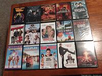 15 DVDs laid out on wooden floor, showing covers and titles clearly for identification
