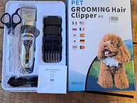 Complete pet grooming hair clipper kit with box showing a poodle image and multiple country flags