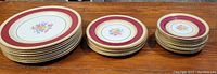 Photo showing the full set of dinner plates, lunch plates, and side plates arranged on a table showing the pattern and condition.