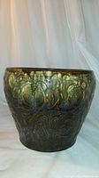 Full view of antique green glazed ceramic plant pot with embossed Art Nouveau design.