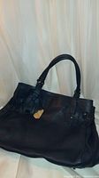 Front view of large navy blue leather handbag showing the overall shape, handles, and textured leather.