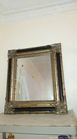 Full view of large rectangular mirror with black and silver distressed frame showing beveled glass edges.