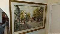 Framed oil painting showing Paris street with flower market and people.