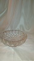 Clear round crystal bowl with diamond and starburst cuts, signed on bottom.