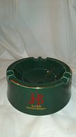 Front view of green ashtray showing J&B Rare Scotch Whisky decal on side