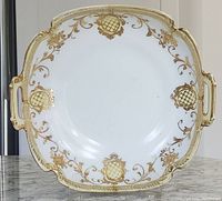 Front view of the antique Nippon squared bowl displaying the gold floral and shield pattern and two handles.