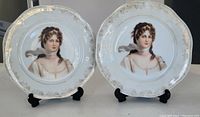 Two antique Bavaria portrait plates displayed side by side on stands, showing overall condition and design.