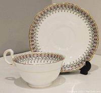Cup and saucer set with Art Deco pattern and gold highlights, displayed with cup in front of the saucer.
