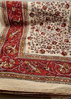 Photo showing the central beige panel with batik floral vine pattern and a wide red-brown detailed border with floral motifs on the large rectangular cotton tablecloth.