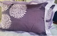 Single decorative purple throw cushion photo showing lavender floral embroidery and ruffled border.