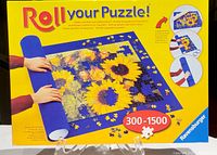 Photo of Ravensburger Roll Your Puzzle box showing mat with sunflower puzzle and roll-up instructions.