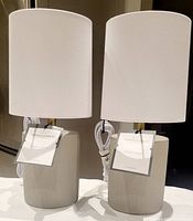 Pair of Threshold table lamps with ceramic bases and white fabric shades, new with tags and wiring still attached.